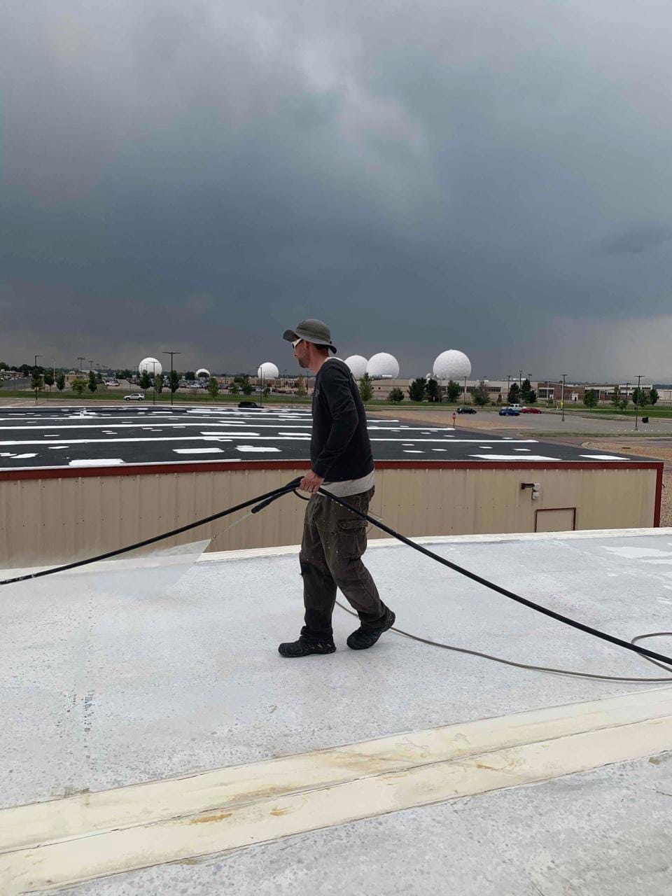 roofing contractor applying a roof coating on a commercial roofing system 